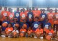 Group photo of young boys and girls in branded Flames Basketball and LBA jerseys during youth training camp at Stella Maris Gym in Monrovia, Liberia.