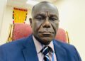 Former Deputy Transport Minister J. Ebenezer Kolliegbo sits in his office, sharply criticizing the outsourcing of vehicle licensing to a foreign-controlled firm.