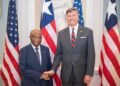 Liberian President Joseph Boakai shakes hands with U.S. Deputy Secretary of State Christopher Landau during a bilateral meeting in Washington, D.C., flanked by Liberian and American flags