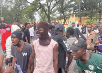 Masked and unmasked youth protestors shouting during July 17 protest in Monrovia, Liberia.