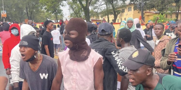 Masked and unmasked youth protestors shouting during July 17 protest in Monrovia, Liberia.