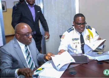 Inspector General Gregory Coleman and AME University President Rev. Dr. Alvin E. Attah sign an MOU to enhance police training and academic collaboration in Liberia.
