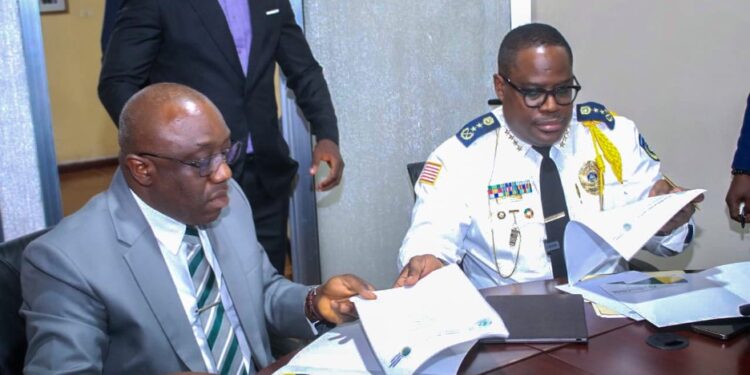 Inspector General Gregory Coleman and AME University President Rev. Dr. Alvin E. Attah sign an MOU to enhance police training and academic collaboration in Liberia.