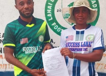 Francisco T. Hinneh receives appointment letter as head coach of Lahai Dream United Football Academy, flanked by a club official in front of the team’s logo in St. Paul Bridge, Liberia.
