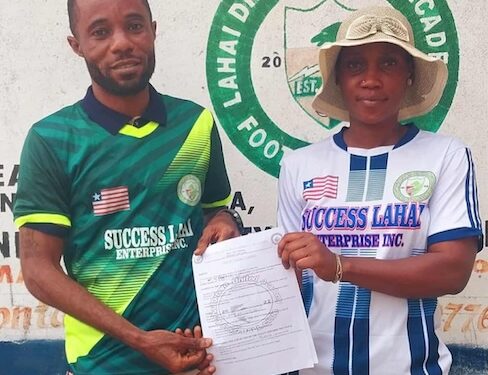 Francisco T. Hinneh receives appointment letter as head coach of Lahai Dream United Football Academy, flanked by a club official in front of the team’s logo in St. Paul Bridge, Liberia.