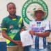 Francisco T. Hinneh receives appointment letter as head coach of Lahai Dream United Football Academy, flanked by a club official in front of the team’s logo in St. Paul Bridge, Liberia.