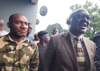 Senator Momo Cyrus flanked by police and protesters after chaos erupted at Capitol Hill during the Enough is Enough protest in Monrovia