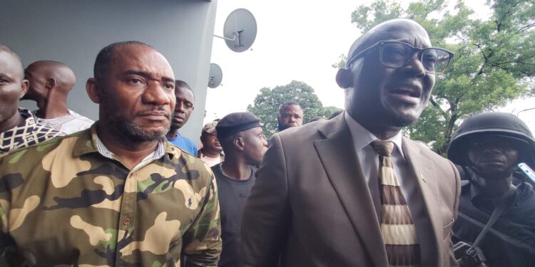 Senator Momo Cyrus flanked by police and protesters after chaos erupted at Capitol Hill during the Enough is Enough protest in Monrovia