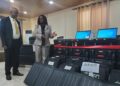 NEC Chairperson Davidetta Browne Lansanah presents biometric voter registration kits to NIR Executive Director Andrew Peters during official handover in Monrovia