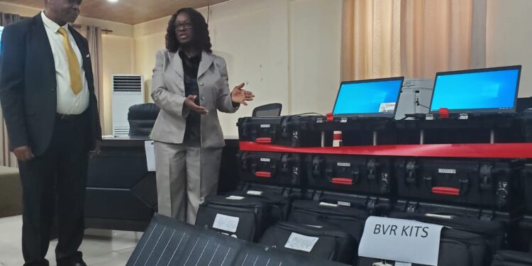 NEC Chairperson Davidetta Browne Lansanah presents biometric voter registration kits to NIR Executive Director Andrew Peters during official handover in Monrovia