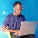 Liberian journalist Nukanah Kollie working on a laptop