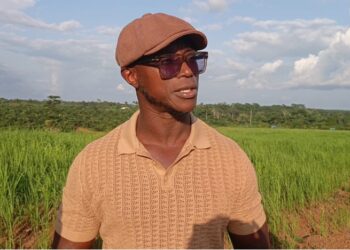 Quanuquanei Alfred Karmue stands on farmland cultivated by Panta Pride in Bong County, Liberia.