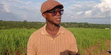 Quanuquanei Alfred Karmue stands on farmland cultivated by Panta Pride in Bong County, Liberia.