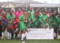 Shaita Angels FC celebrate with trophy and symbolic $1,000 check after winning the inaugural Caresyburg International Cup in 2024.