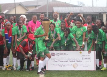 Shaita Angels FC celebrate with trophy and symbolic $1,000 check after winning the inaugural Caresyburg International Cup in 2024.