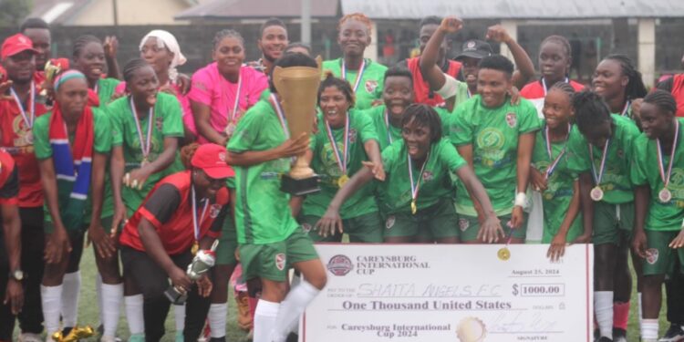 Shaita Angels FC celebrate with trophy and symbolic $1,000 check after winning the inaugural Caresyburg International Cup in 2024.