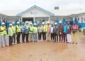 WAHO and Liberian health officials pose in front of the under-construction cross-border maternal and child health center in Bo-Waterside, Grand Cape Mount County.