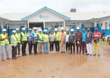 WAHO and Liberian health officials pose in front of the under-construction cross-border maternal and child health center in Bo-Waterside, Grand Cape Mount County.