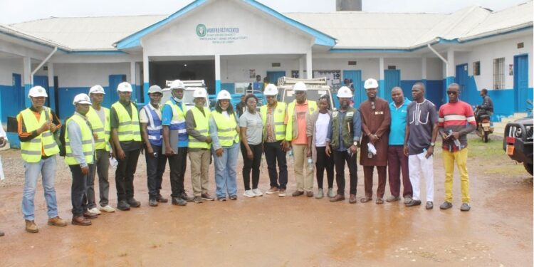 WAHO and Liberian health officials pose in front of the under-construction cross-border maternal and child health center in Bo-Waterside, Grand Cape Mount County.