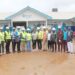 WAHO and Liberian health officials pose in front of the under-construction cross-border maternal and child health center in Bo-Waterside, Grand Cape Mount County.