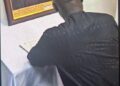 Former Liberian President George Weah signs the Book of Condolence in Abuja for late Nigerian President Muhammadu Buhari, whose framed portrait is displayed beside him, during a solemn tribute honoring Buhari’s legacy as a regional pillar of stability