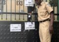 Liberian court officer sealing the gate of Mutual Benefits Assurance Company following a writ of execution from the Commercial Court of Liberia