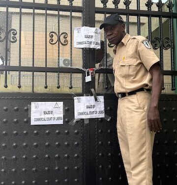 Liberian court officer sealing the gate of Mutual Benefits Assurance Company following a writ of execution from the Commercial Court of Liberia