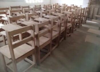 Wooden school armchairs arranged in a classroom in rural Grand Kru County