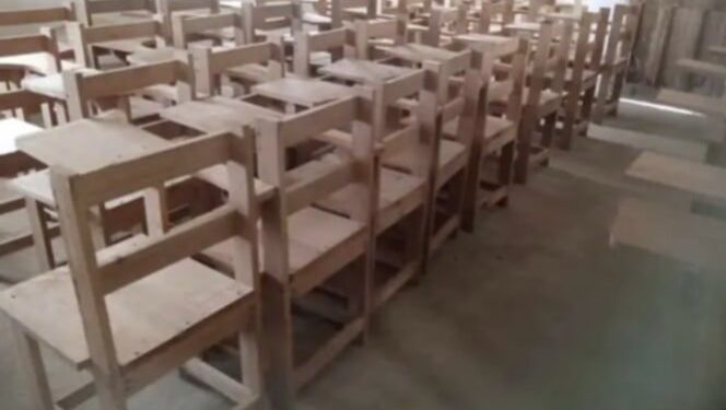 Wooden school armchairs arranged in a classroom in rural Grand Kru County