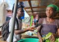 A female vendor in Sirleaf Market, Gbarnga, Bong County, speaks to a local journalist about new Liberian hospital fees affecting poor citizens