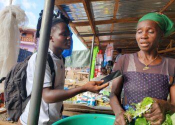 A female vendor in Sirleaf Market, Gbarnga, Bong County, speaks to a local journalist about new Liberian hospital fees affecting poor citizens