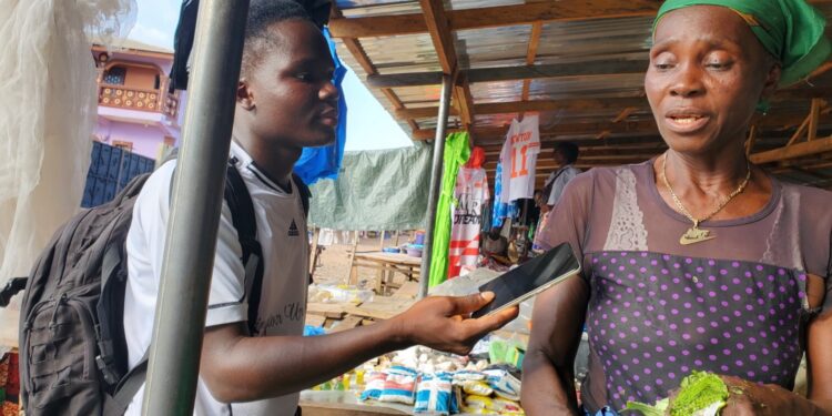 A female vendor in Sirleaf Market, Gbarnga, Bong County, speaks to a local journalist about new Liberian hospital fees affecting poor citizens