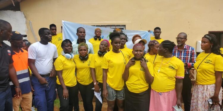Rehabilitated women in yellow shirts pose after graduating from Liberia’s Center for Rehabilitation and Reintegration during an anti-drug rally in Paynesville