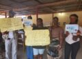 University of Liberia students hold placards appealing for help to fund heart surgery for their classmate Augustine Gbabai