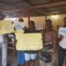 University of Liberia students hold placards appealing for help to fund heart surgery for their classmate Augustine Gbabai