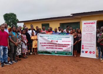 Group photo of participants at ActionAid Liberia’s County-Level National People’s Summit on Climate Justice in Bong County, holding a banner promoting agroecology, people-driven climate finance, and sustainable solutions for Liberia.