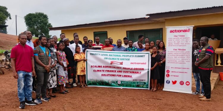 Group photo of participants at ActionAid Liberia’s County-Level National People’s Summit on Climate Justice in Bong County, holding a banner promoting agroecology, people-driven climate finance, and sustainable solutions for Liberia.
