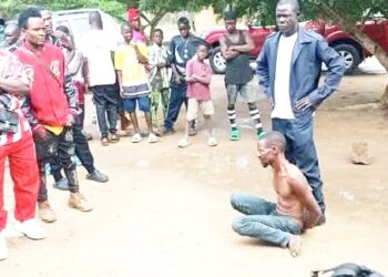Crowd gathers around arrested Guinean national accused of plotting witchcraft assassination attempt against Nimba Senator Samuel G. Kogar in Liberia