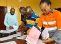 ArcelorMittal Liberia officials review onboarding documents for Grand Bassa youth selected for the 2025 vacation job program.