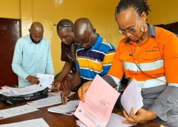 ArcelorMittal Liberia officials review onboarding documents for Grand Bassa youth selected for the 2025 vacation job program.