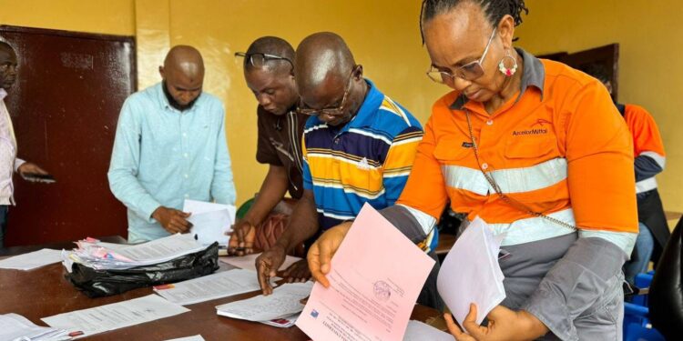 ArcelorMittal Liberia officials review onboarding documents for Grand Bassa youth selected for the 2025 vacation job program.