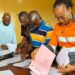 ArcelorMittal Liberia officials review onboarding documents for Grand Bassa youth selected for the 2025 vacation job program.
