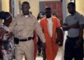 Defendant Bill Jallah in orange prison jumpsuit escorted by officers at Criminal Court ‘B’ in Monrovia after pleading guilty to murdering Princess Zuo.