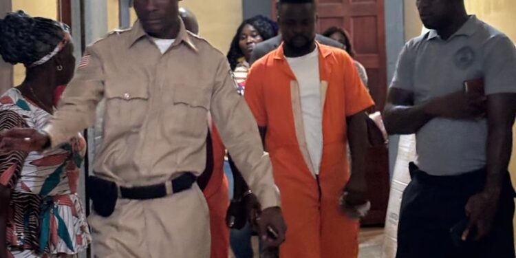 Defendant Bill Jallah in orange prison jumpsuit escorted by officers at Criminal Court ‘B’ in Monrovia after pleading guilty to murdering Princess Zuo.