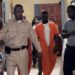 Defendant Bill Jallah in orange prison jumpsuit escorted by officers at Criminal Court ‘B’ in Monrovia after pleading guilty to murdering Princess Zuo.