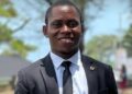 Blamo N. Toe, LEGISPOOL presidential aspirant, pictured in a black suit and tie, smiling during the launch of his ELEVATE platform for press reform.
