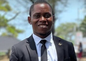 Blamo N. Toe, LEGISPOOL presidential aspirant, pictured in a black suit and tie, smiling during the launch of his ELEVATE platform for press reform.