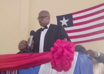 Resident Judge Boimah Kontoe speaking at a judicial program in Gbarnga, Bong County, with the Liberian flag in the background.