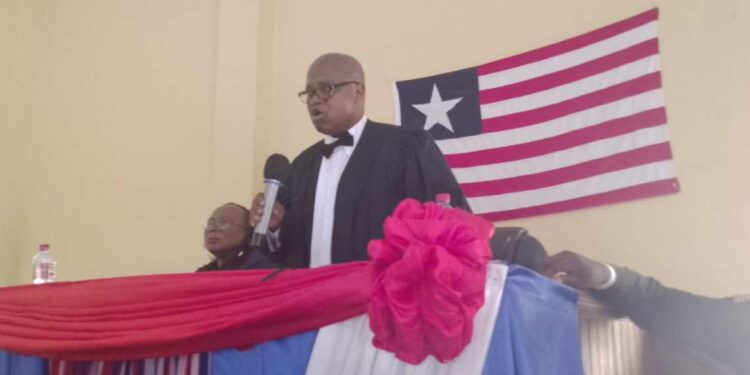 Resident Judge Boimah Kontoe speaking at a judicial program in Gbarnga, Bong County, with the Liberian flag in the background.