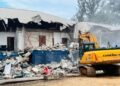 Excavator demolishes CDC headquarters building in Monrovia during court-ordered eviction operation.